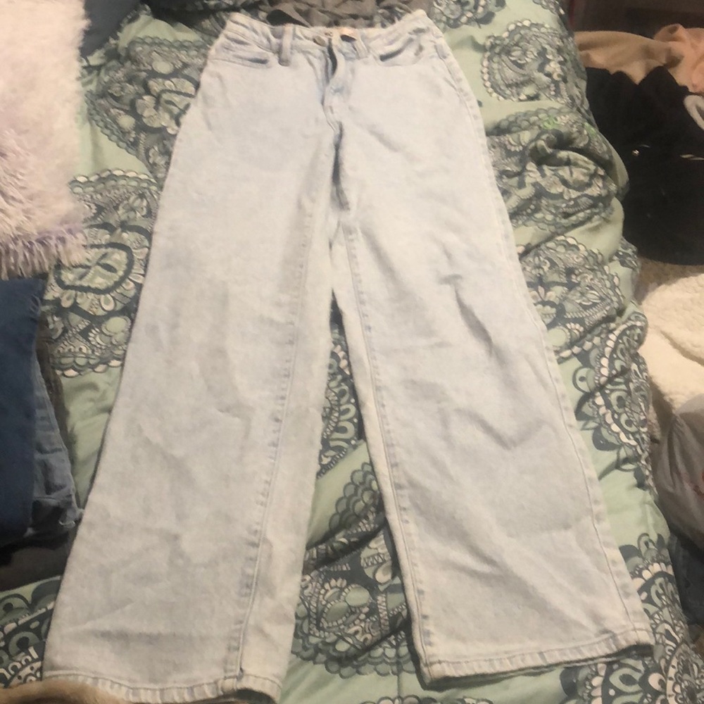 Tight around the waist and loose on the bottom. Light colored jeans